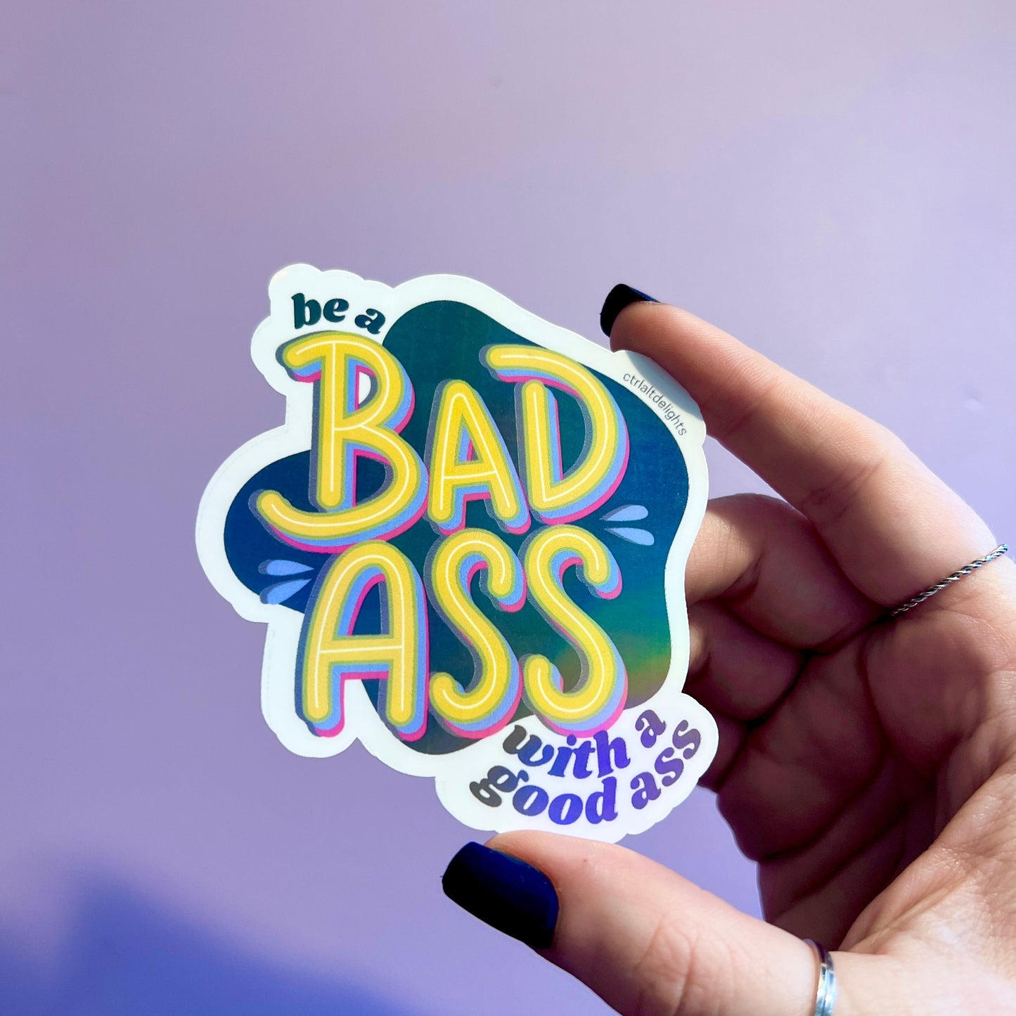 This vibrant vinyl sticker with the phrase 'Be a Badass with a Good Ass' is perfect for adding motivational flair to your laptop, water bottle, or journal. The playful yet bold design is sure to inspire confidence wherever you place it.