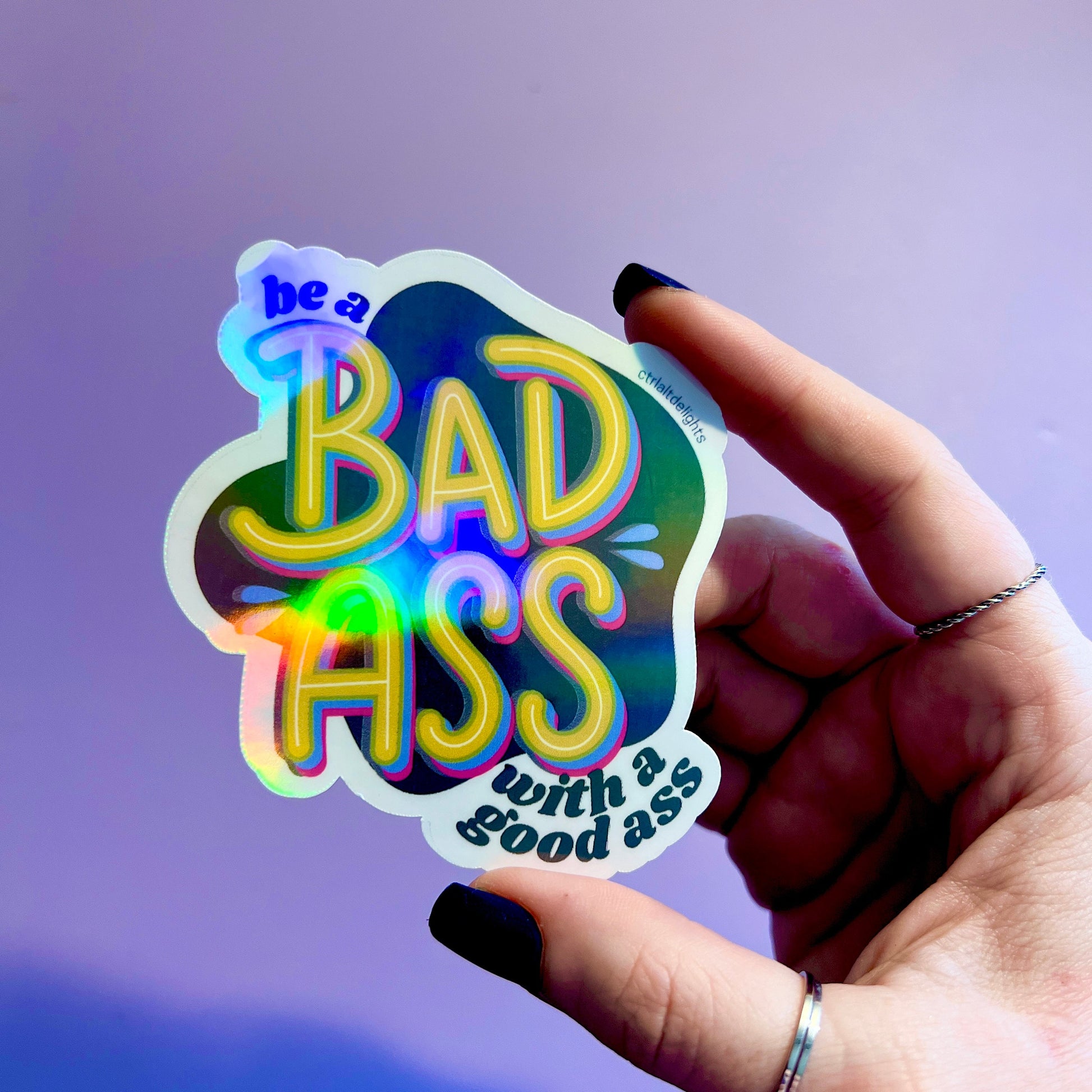 This vibrant vinyl sticker with the phrase 'Be a Badass with a Good Ass' is perfect for adding motivational flair to your laptop, water bottle, or journal. The playful yet bold design is sure to inspire confidence wherever you place it.