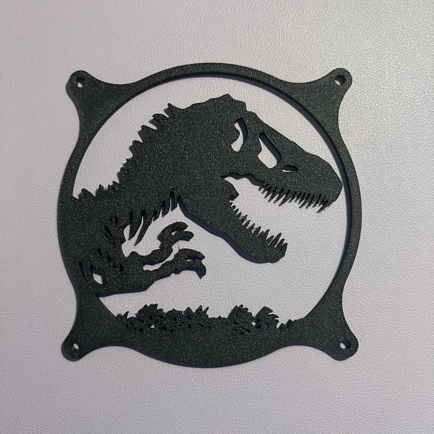 This 3D printed T-Rex dinosaur fan grill cover is perfect for adding a prehistoric touch to your gaming setup. Designed to fit PC fan grills, it adds protection and style. Ideal for dinosaur and gaming enthusiasts alike.