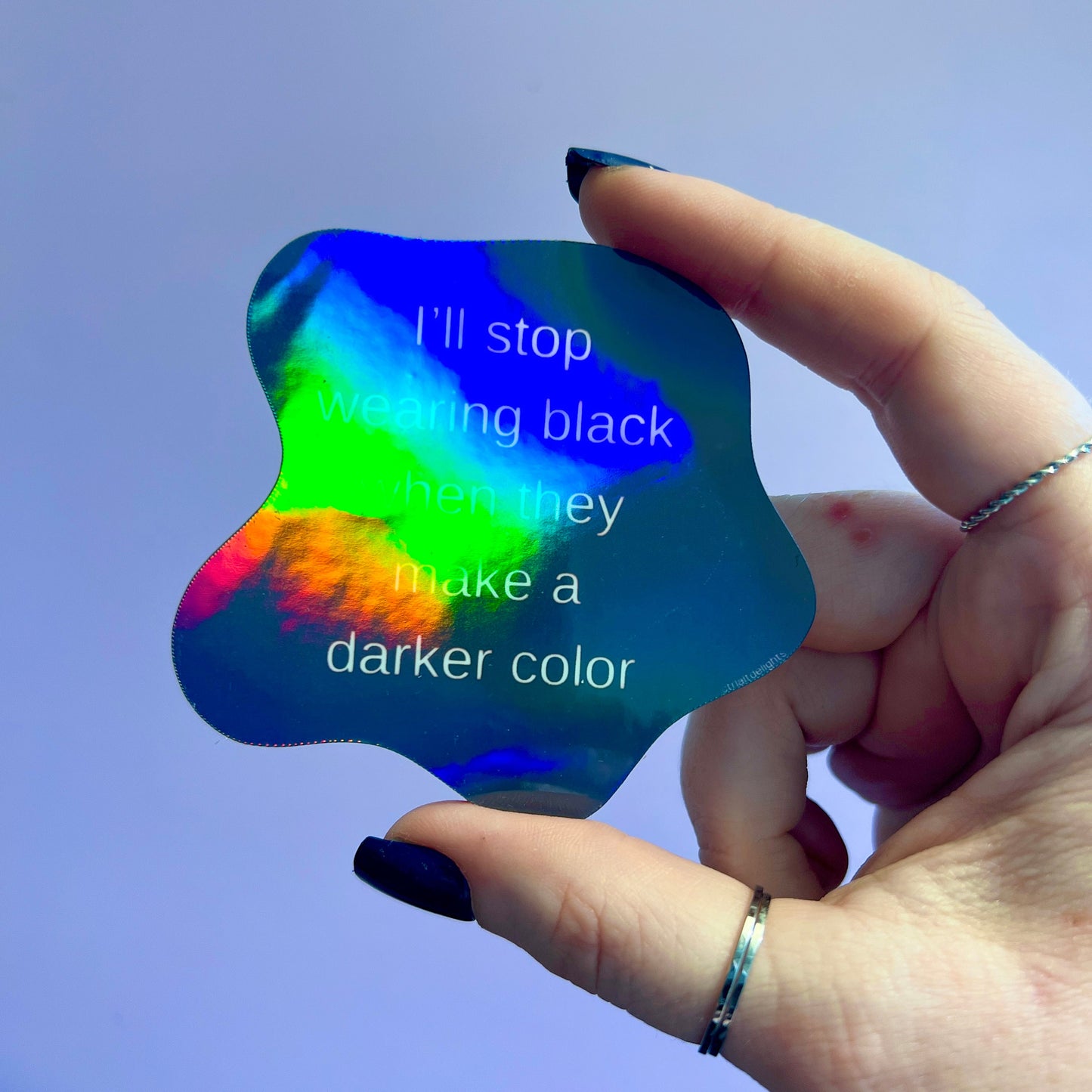 Holographic sticker featuring a bold gothic quote: I'll stop wearing black when they make a darker color. Perfect for laptops, notebooks, or water bottles. Shiny, eye-catching design for goths and dark fashion lovers.