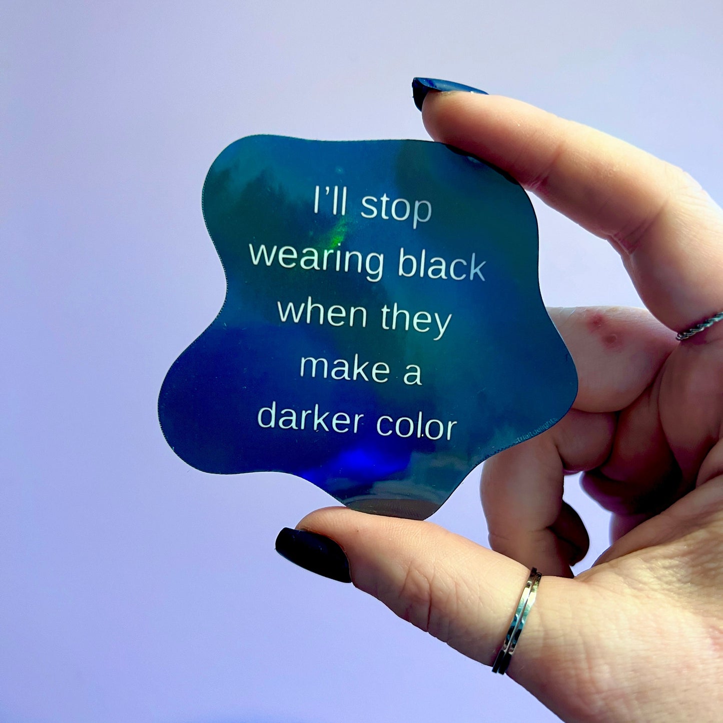 Holographic sticker featuring a bold gothic quote: I'll stop wearing black when they make a darker color. Perfect for laptops, notebooks, or water bottles. Shiny, eye-catching design for goths and dark fashion lovers.