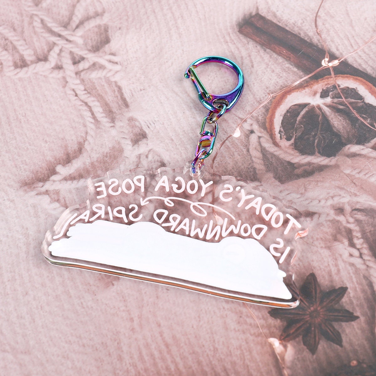 A clear acrylic keyring with a crying frog on a yoga mat, with the words today's yoga pose is downward spiral, in curling font above it. Attached to a blue iridescent claw clasp. Back View.