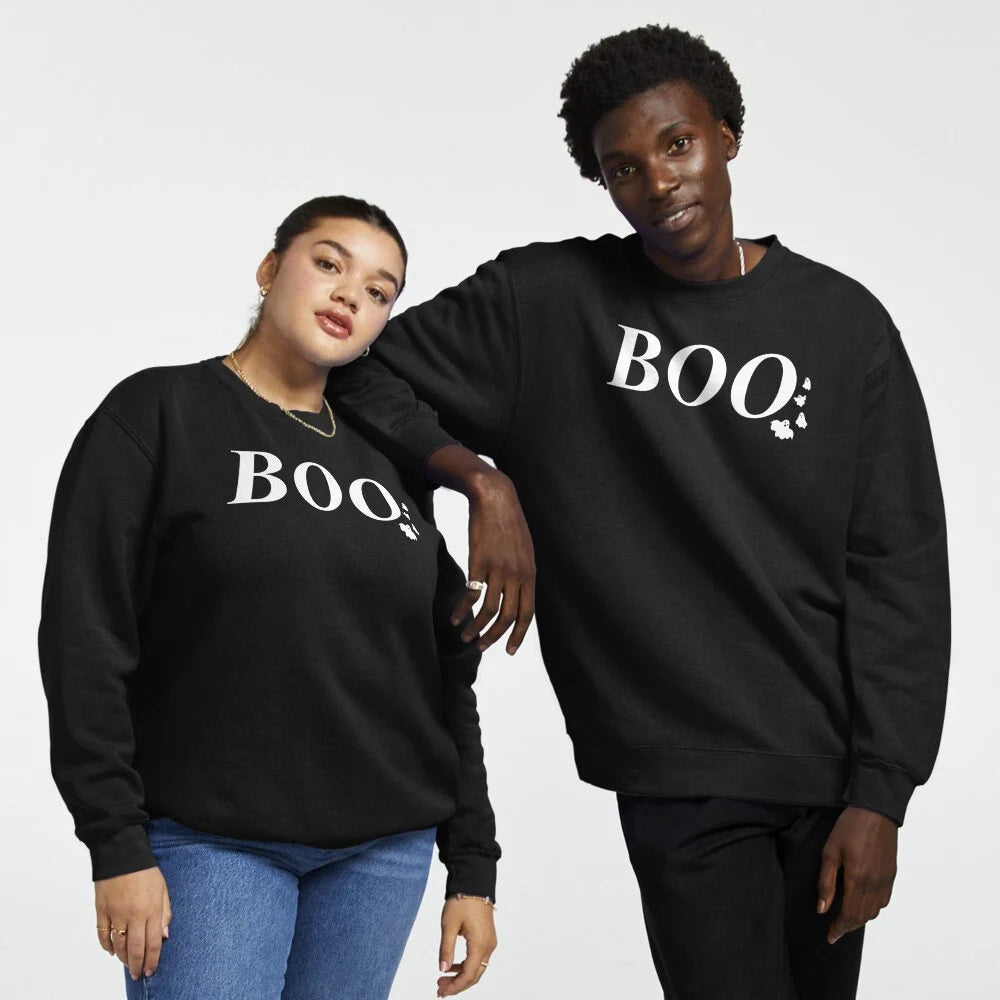 Black sweatshirt with BOO text in white and small ghost graphics, perfect for Halloween. Cozy and fun for fall, great for parties or casual wear, adding a playful touch to your spooky season outfit. Featured on 2 models.