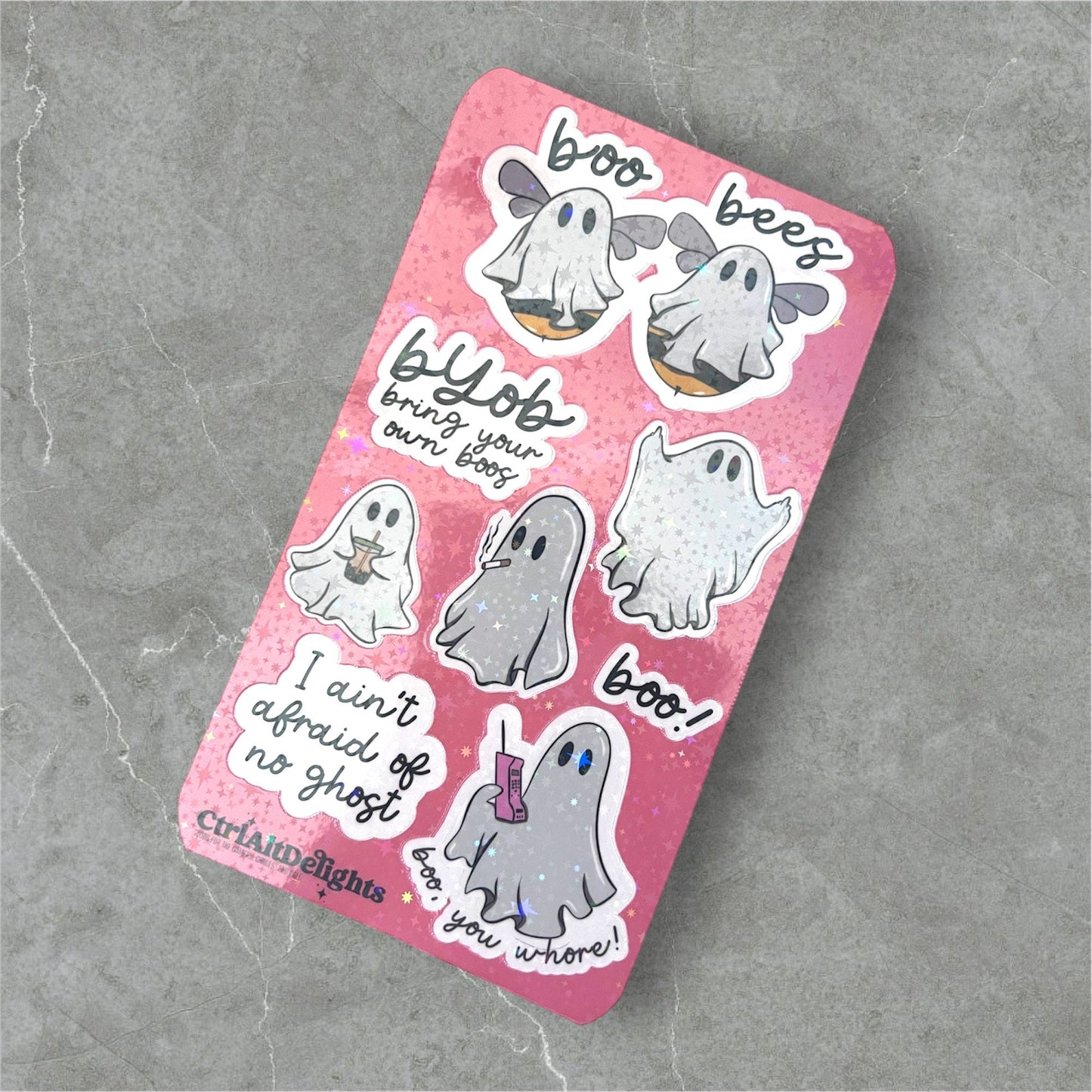 Fun ghost-themed sticker sheet featuring cute and playful ghost illustrations with humorous sayings like ‘Boo Bees’ and ‘I Ain’t Afraid of No Ghost.’ Perfect for Halloween or spooky fun decorating. Holographic finish.