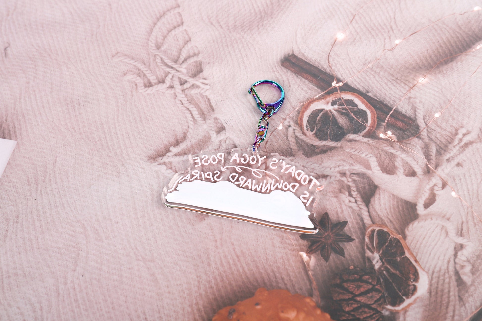 A clear acrylic keyring with a crying frog on a yoga mat, with the words today's yoga pose is downward spiral, in curling font above it. Attached to a blue iridescent claw clasp. Back view.