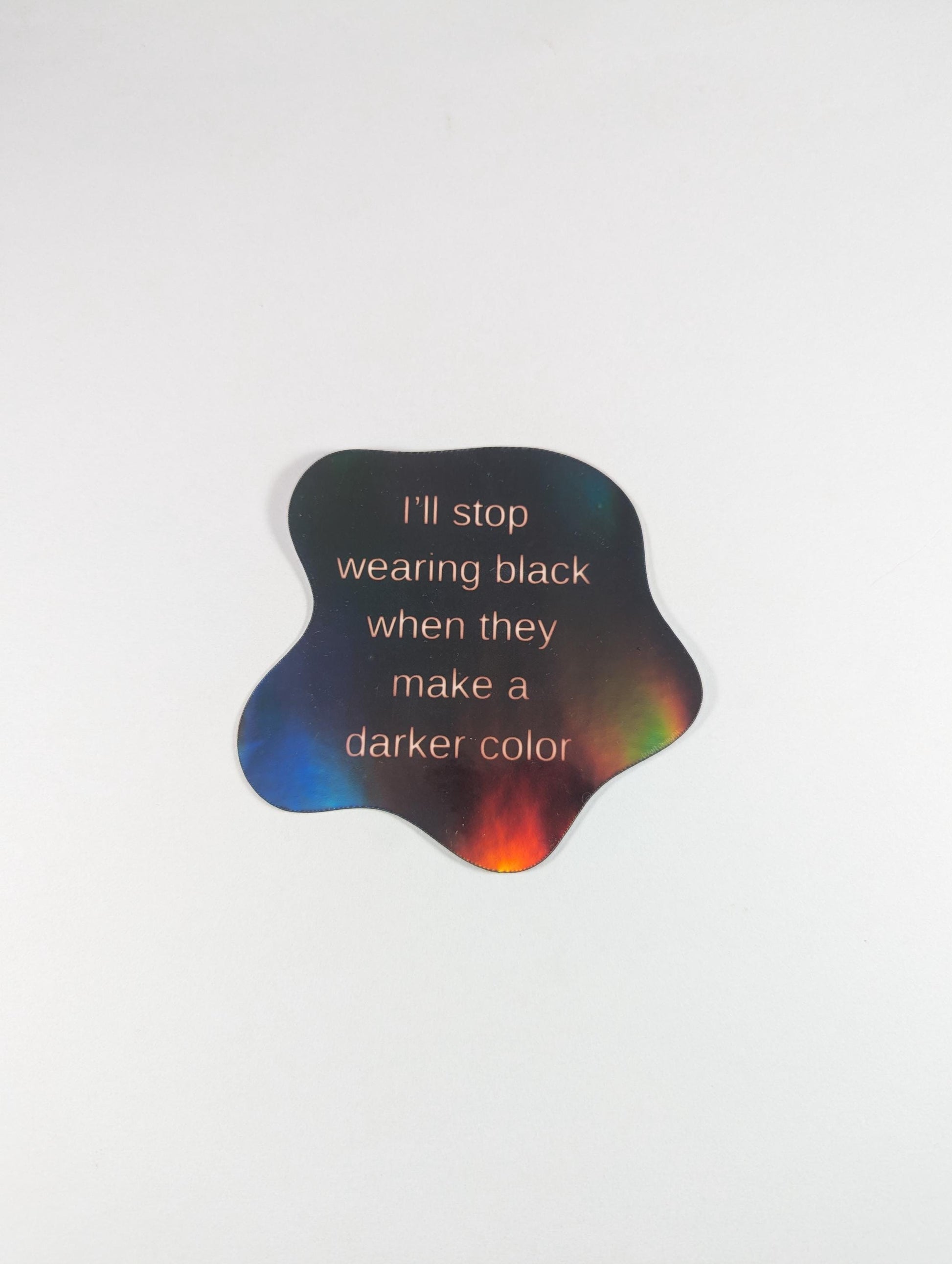 Holographic sticker featuring a bold gothic quote: I'll stop wearing black when they make a darker color. Perfect for laptops, notebooks, or water bottles. Shiny, eye-catching design for goths and dark fashion lovers.