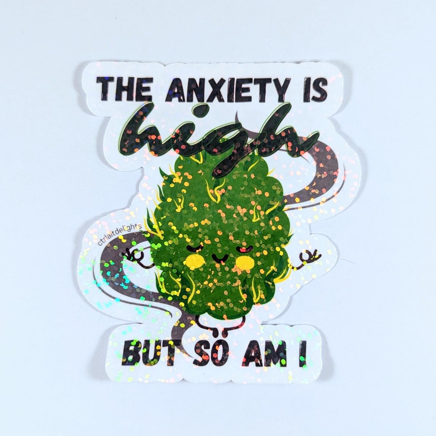 Holographic sticker featuring a cute cannabis bud meditating with the phrase 'The Anxiety is High But So Am I.' A perfect gift for stoners or anyone who enjoys playful anxiety relief humor.