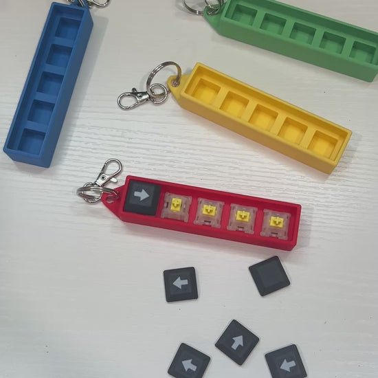 Helldivers 2-inspired keychain clicker featuring mechanical arrow keys. A perfect fidget toy for gamers, stress relief, and tactical clicking action.